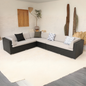 A large L-shaped outdoor sectional sofa with cushions in various colors, including a red accent pillow, placed on a white background.